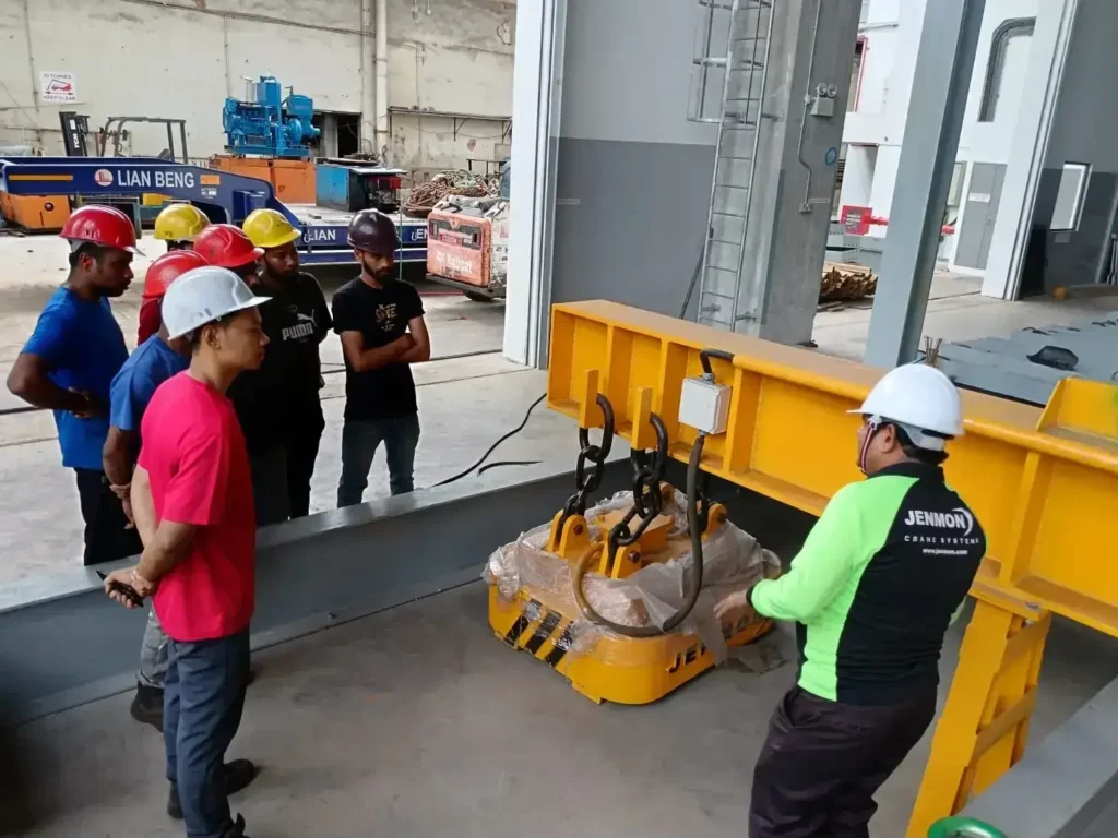 Industrial crane training session in a manufacturing or heavy equipment workshop